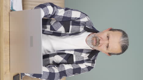 Vertical-video-of-Old-man-looking-at-laptop-gets-frustrated.